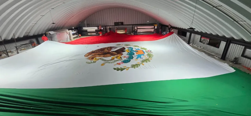 Bandera monumental sublimada extendida en la planta de producción